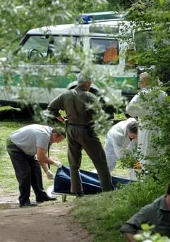 Bestatter und Kriminalbeamte bereiten am Dienstag (04.05.2004) den Abtransport einer Leiche am Ufer der Nürnberger Pegnitzauen vor. Nach einer Suchaktionen der Polizei wurde eine Leiche von Polizeitauchern in Höhe der Eisenbahnbrücke "Fuchsloch" gefunden. Dabei handelt es sich um die 21-jährige Frau, die am vergangenen Mittwochabend von ihrer Internetbekanntschaft erstochen und anschliesend in den Fluß geworfen wurde. (Foto: dpa)