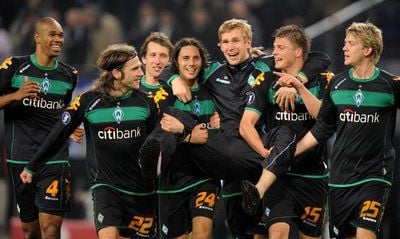 Die Bremer Spieler tragen den verletzten Per Mertesacker (3.v.l) nach dem Schlusspfiff in die Bremer Fankurve. Der Hamburger SV verliert gegen Werder Bremen mit 2:3. Damit zieht Bremen ins UEFA-Pokalfinale ein. (FOTO: DPA)