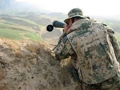 Ein deutscher Soldat schaut am 05.05.2006 bei einer Patrouille einige Kilometer vom Lager bei Masar-i-Scharif entfernt durch ein Fernrohr von Tchibo. Die für den Schutz des neuen Bundeswehr-Lagers im nordafghanischen Masar-i-Scharif zuständigen deutschen Soldaten sind lückenhaft ausgerüstet. Das sogenannte Spektiv - das weitaus stärker vergrößert als ein Fernglas und bei der Kaffeerösterkette für 89,90 Euro erhältlich ist - hat der Patrouillenführer aus eigener Tasche bezahlt und selber mitgebracht. (Foto: dpa)