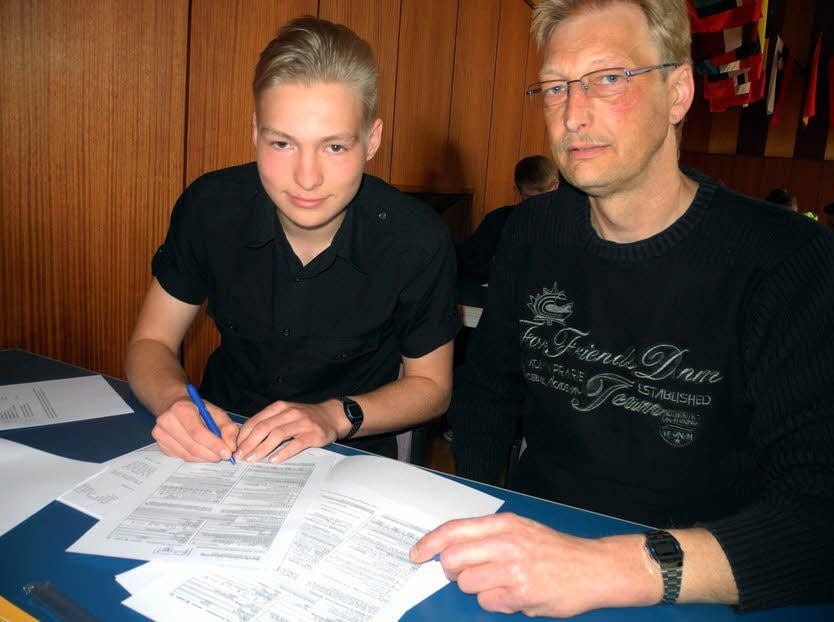 Florian Wiegand aus Prettin unterschreibt gemeinsam mit seinem Vater Marcel das begehrte Dokument.