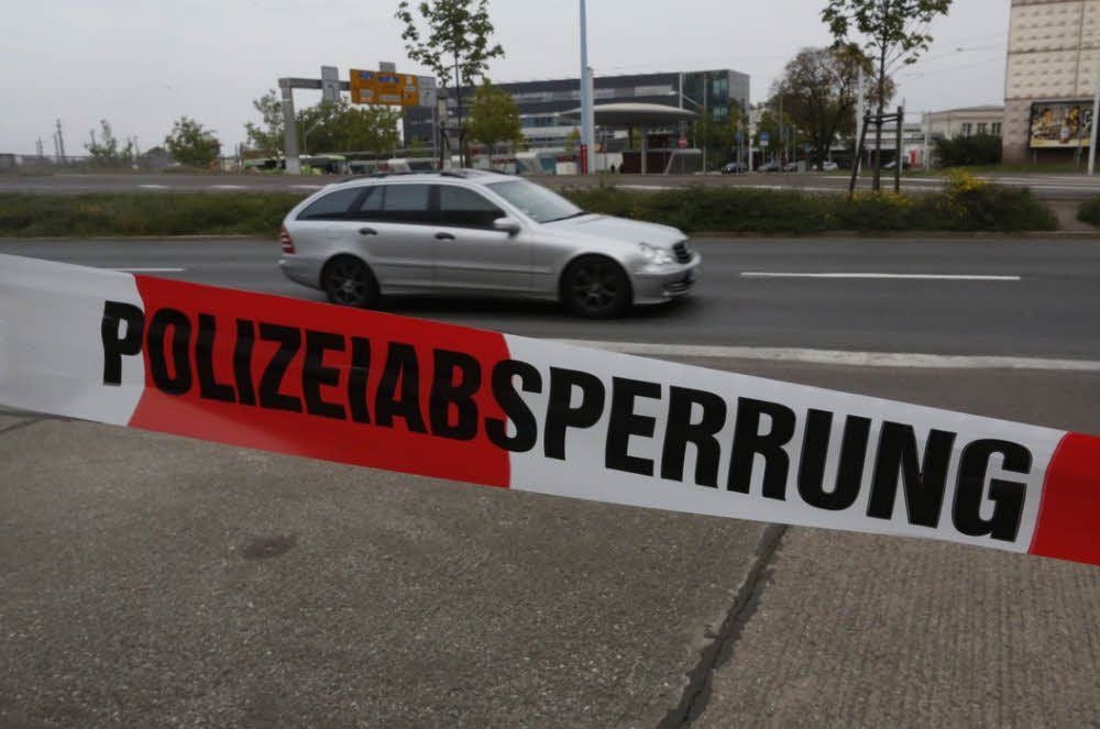 Mit Handzetteln und Absperrband vor dem Hotel wird vor dem Verkehr auf der Merseburger Straße gewarnt.