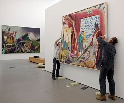 Mitarbeiter des Museums der Bildenden Künste Leipzig hängen in der im Aufbau befindlichen Ausstellung «Neo Rauch.Begleiter» das Bild «Scheune» (2003) auf. (FOTO: DPA)