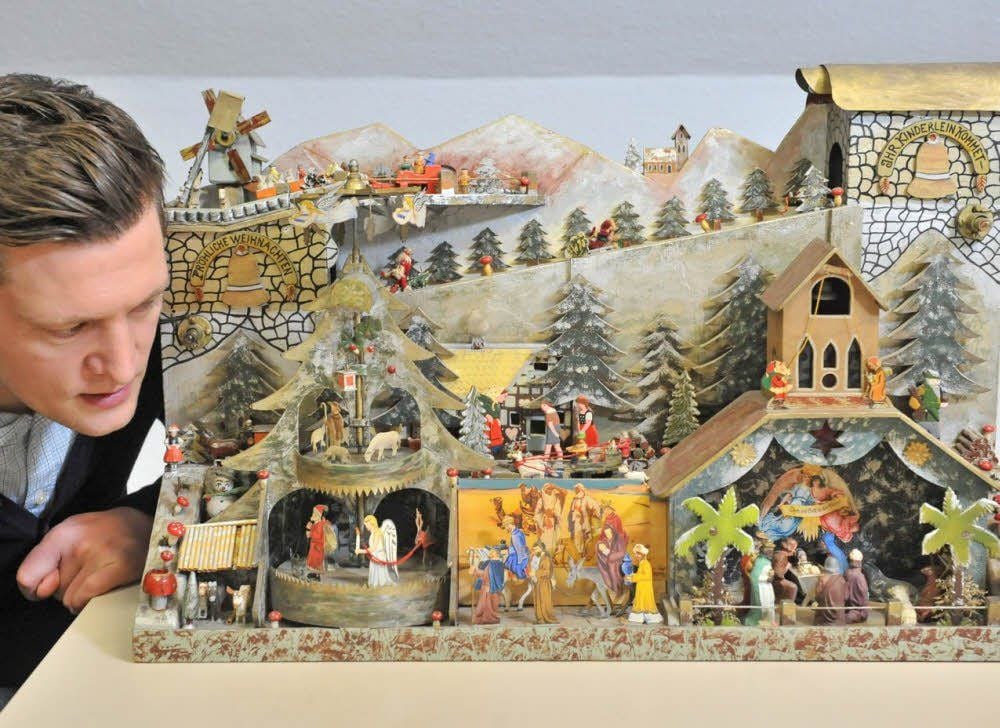 Eine bunte Weihnachtswelt auf 70 mal 34 Zentimeter: der Weihnachtsberg im Kreismuseum. Mitarbeiter Steven Pick hat einige Fakten über den Erbauer E. Gierth entdeckt. Dieser hat aus damaligem Alltagsmaterial faszinierenden Detailreichtum geschaffen (r.o.). Die Elektrik ist auf der Rückseite versteckt (r.u.).