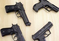 Handfeuerwaffen und täuschend echt wirkende Imitate (rechts oben und unten) liegen während der Landespressekonferenz in Magdeburg auf einem Tisch. (Foto: dpa)