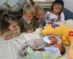 An der Chemnitzer Frauenklinik betrachten Kinder am Donnerstag (16.11.2006) zwei Neugeborene. (Foto: dpa)