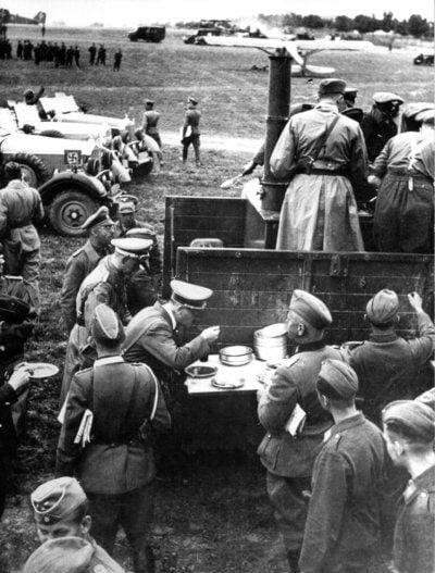 Führer und Reichskanzler Adolf Hitler (Mitte links am Tisch) stärkt sich während eines Besuchs des Kriegsschauplatzes in Polen 1939 mit einem Essen aus der Gulaschkanone. (FOTO: DPA)