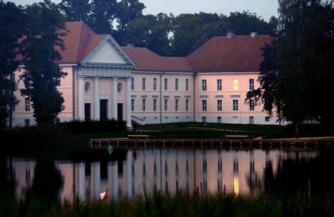 Blick auf die Musikakademie (rechts) und das Theater (links) im Schlosspark von Rheinsberg (Landkreis Ostprignitz-Ruppin), die sich bei spätem Abendlicht im See spiegeln. (ARCHIVFOTO: DPA)