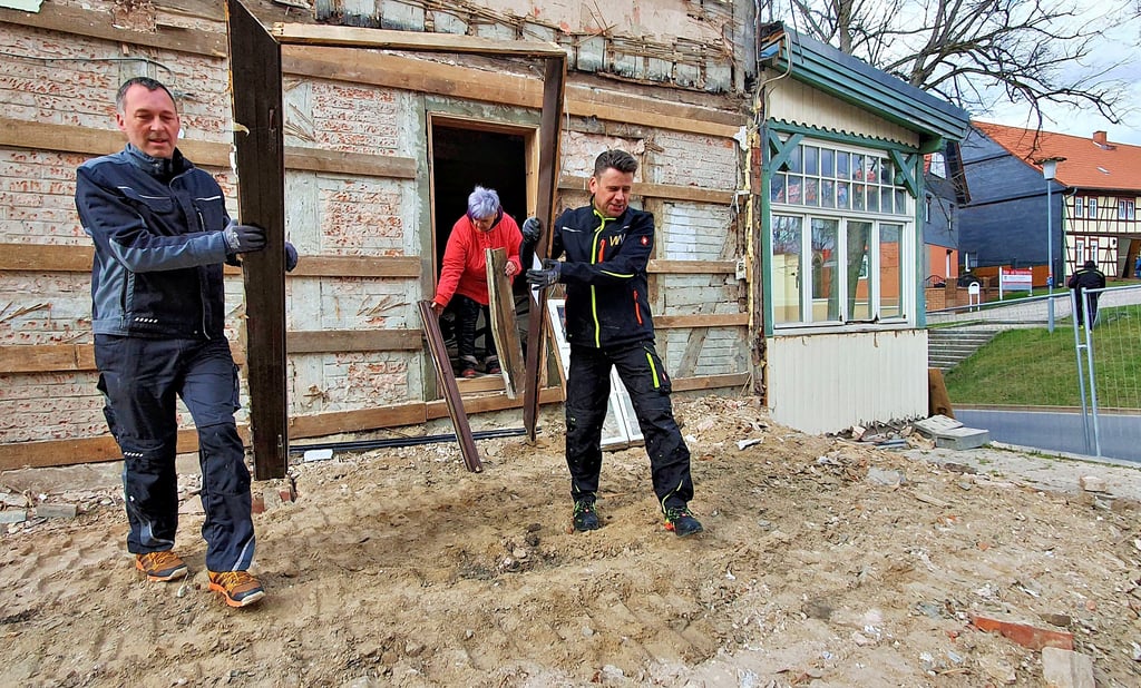 Der Abrissbagger ist schon angerollt. Damit aber etwas von dem Haus mit der Nummer 222 bleibt, sichern die Straßberger verschiedene Bauelemente. Jochen Illmer (l.) und Heiko Schütz tragen einen alten Türrahmen aus dem Abrisshaus; Heike Schoch stellt weitere Teile zum Abtransport bereit.