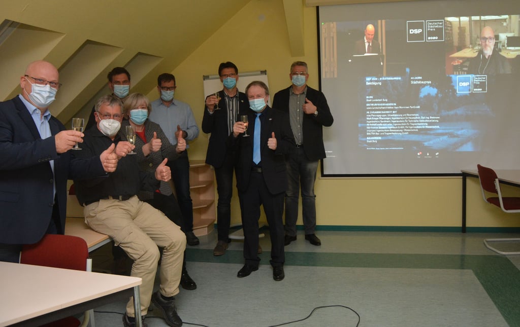 IIm Konferenzraum der Stadtverwaltung verfolgen (v.l.) Clemens Engel, Wolfgang Meyer, Andrea Gottschalk, Robert Holldorf, Sven Wagener, Udo Vogt, Jens Vogler und Bernhard Ruth per Videoübertragung die Verleihung des Deutschen Städtebaupreises 2020. Zugeschaltet war Planer Gero Heck (rechts oben).