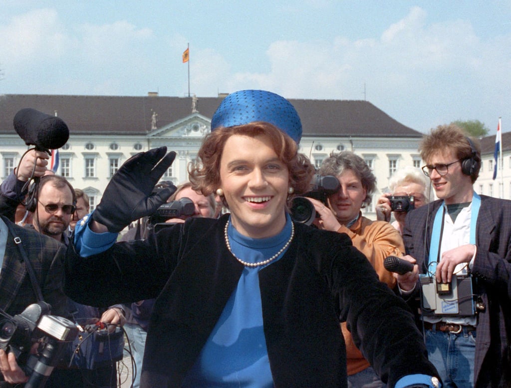 Verkleidet als Königin Beatrix der Niederlande winkt der Komiker Hape Kerkeling vor Schloss Bellevue für die Presse (1991).