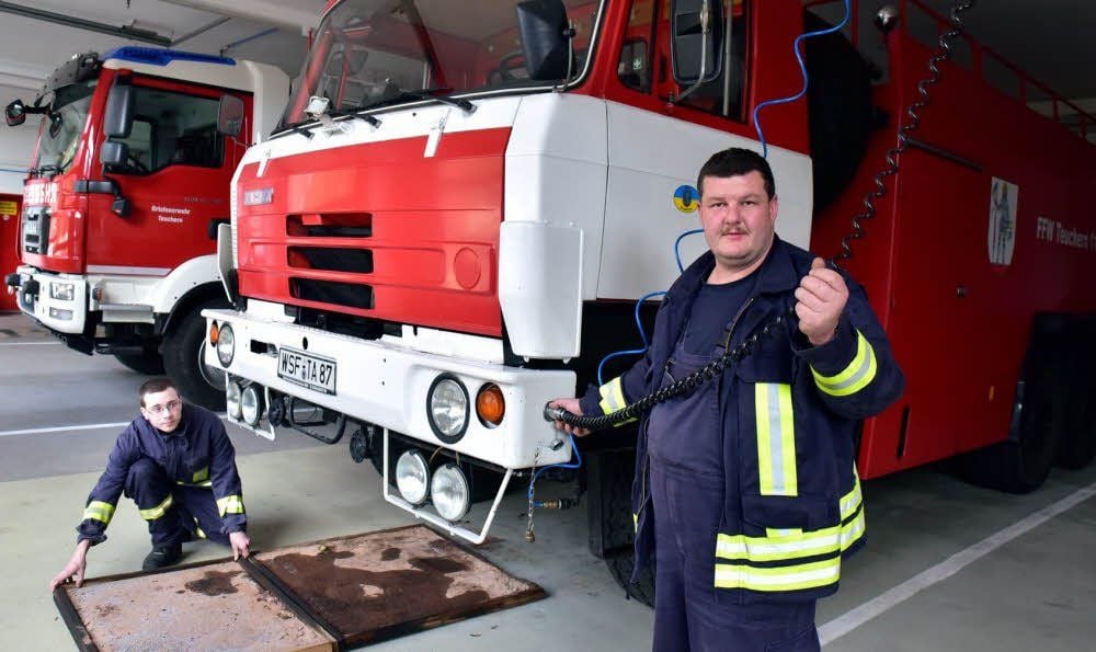 Marco Föhlisch, Ortswehrleiter von Teuchern (vorn) und Feuerwehrmann Sebastian Böhme zeigen das fast 30 Jahre alte Tanklöschfahrzeug der Teucherner Ortswehr von 1987, das über ein Fassungsvermögen von 8 700 Litern Löschwasser verfügt. Es soll demnächst ausgemustert werden. Auch, weil der Motor des Wagens undicht ist und deshalb ab und zu Öl austritt, das mit einer speziellen Wanne aufgefangen werden muss.