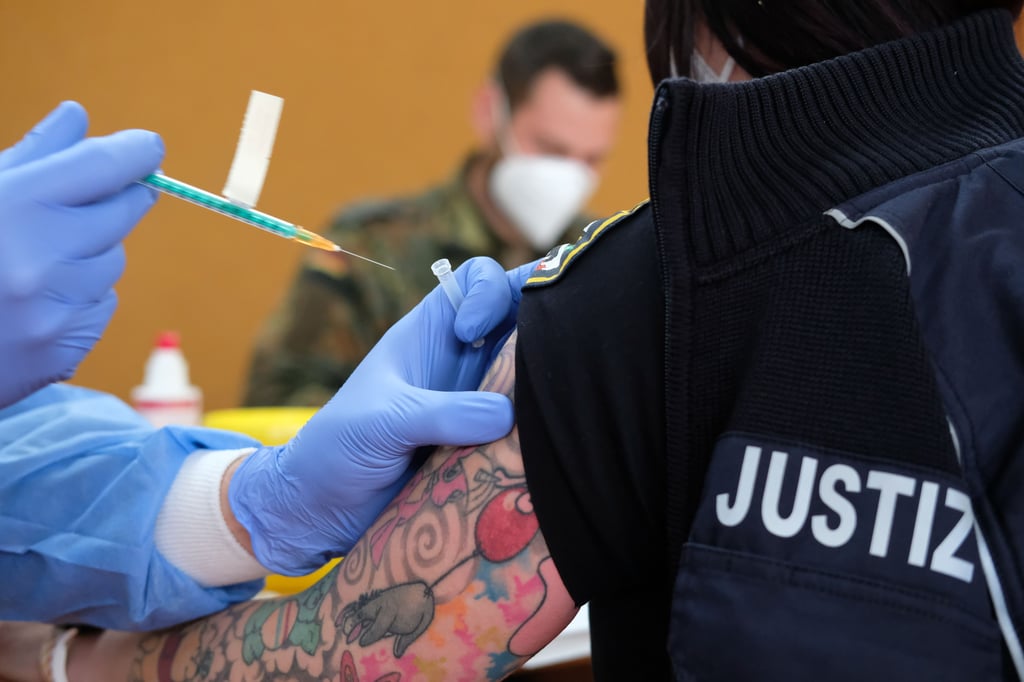 Eine Justizbeamtin wird in der Turnhalle der Justizvollzugsanstalt Volkstedt geimpft.