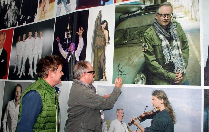Heinz Rudolf Kunze signiert an der Mauerbühne sein Porträt, bevor er von Torsten Sielmon (l.) durch die Ausstellung geführt wird.