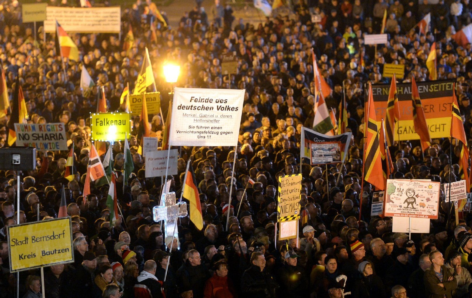 Anhänger der Pegida demonstrieren am Abend des 26.10.2015 auf dem Theaterplatz mit Plakaten und Deutschland-Fahnen.