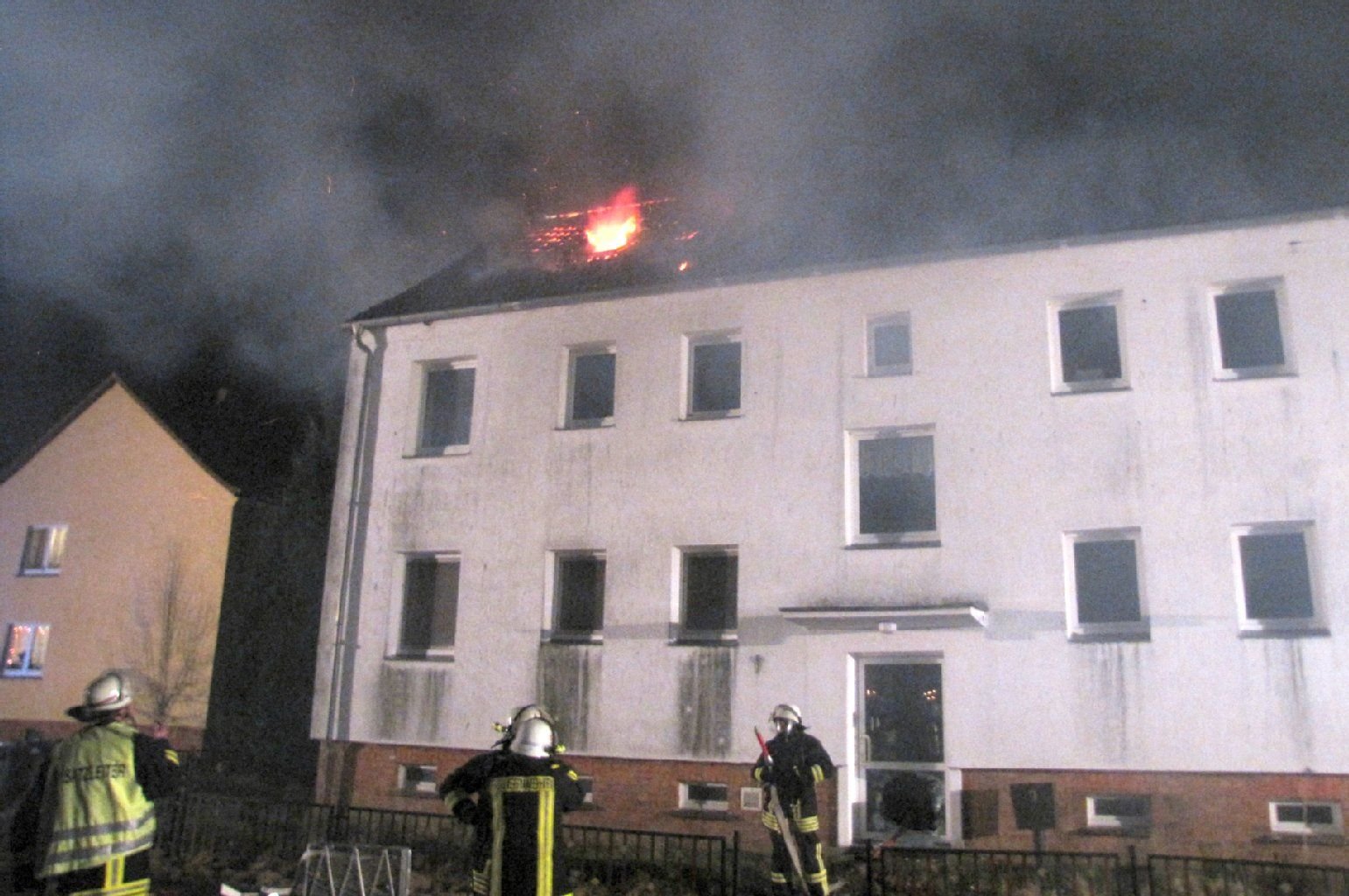 Feuerwehrleute löschen ein brennendes Mehrfamilienhaus in Langenapel.