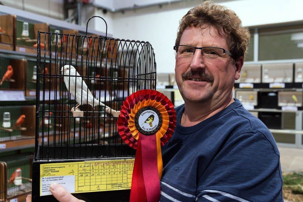 Gerd Werner freut sich mit seinem Kanarienvogel.