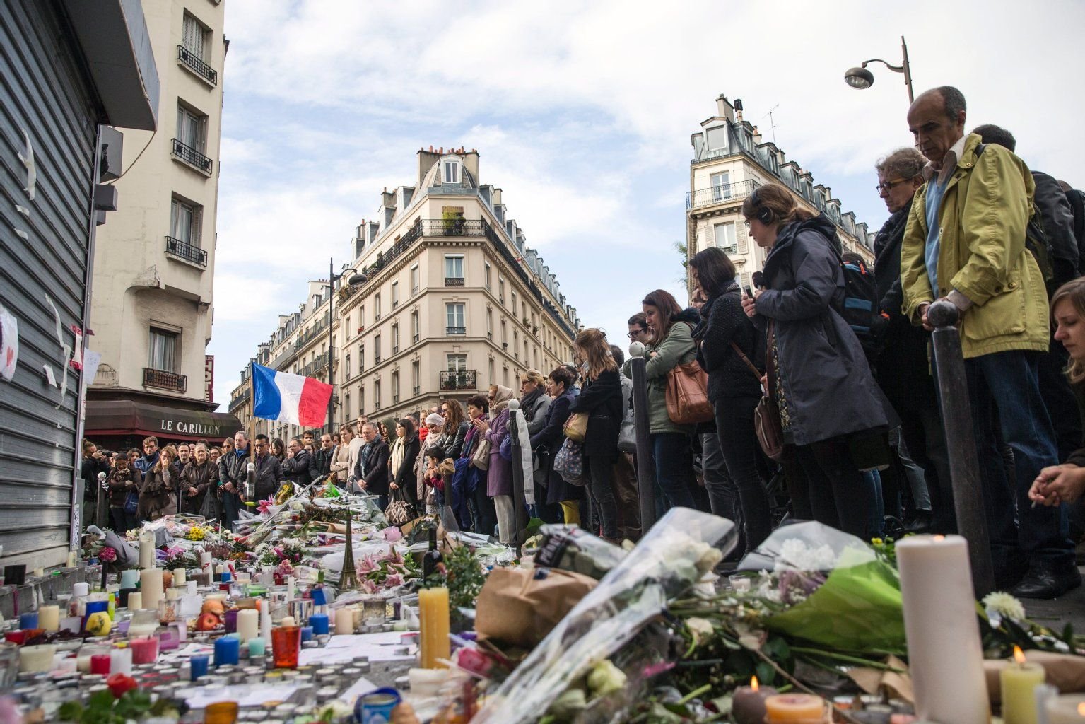 In Paris legen die Menschen vor einem betroffenen Restaurant in Gedenken an die Opfer der Terroranschläge vom 13. November Blumen und Kerzen nieder.