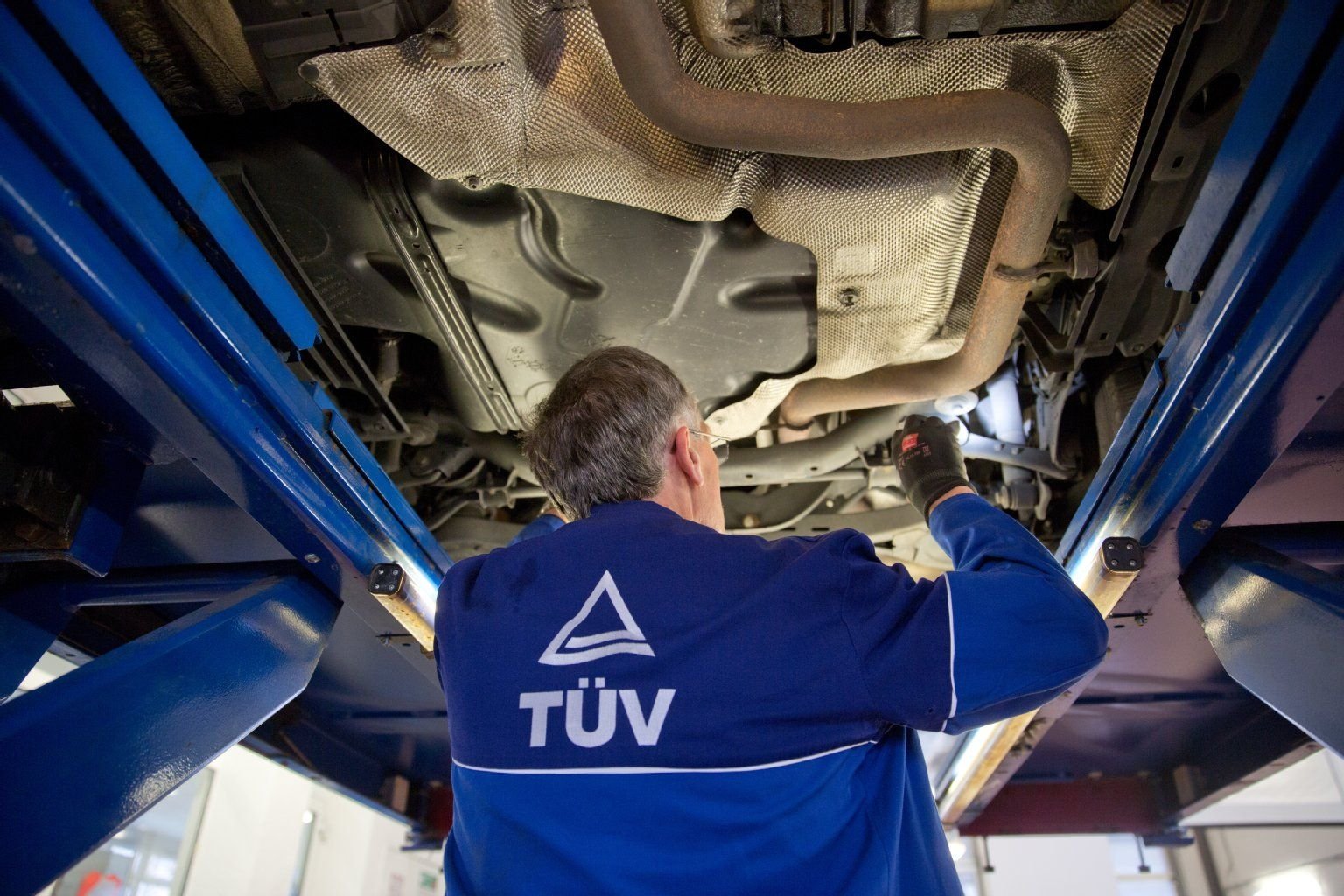 Ein Kfz-Sachverständiger vom TÜV überprüft ein Fahrzeug.