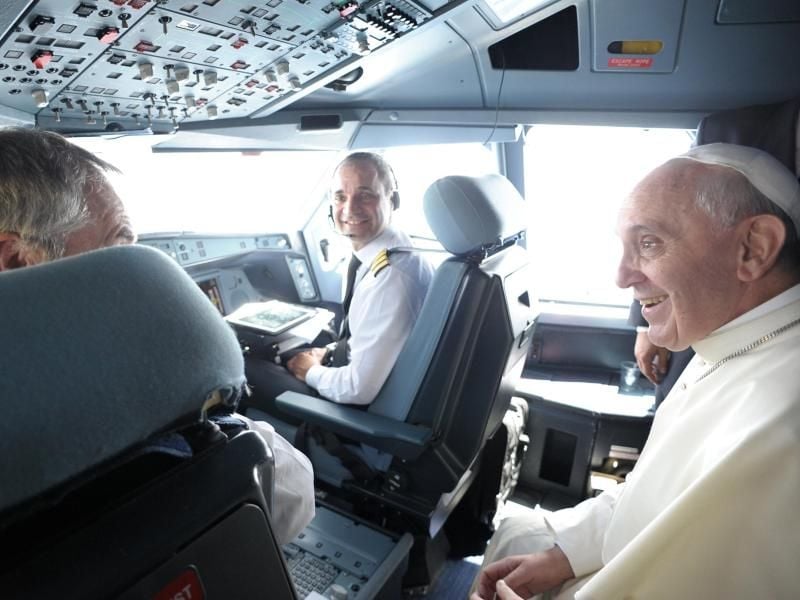 Der Pilot Alberto Colautti von der der italienischen Fluglinie Alitalia (M) und Papst Franziskus im Cockpit. Foto: Osservatore Romano