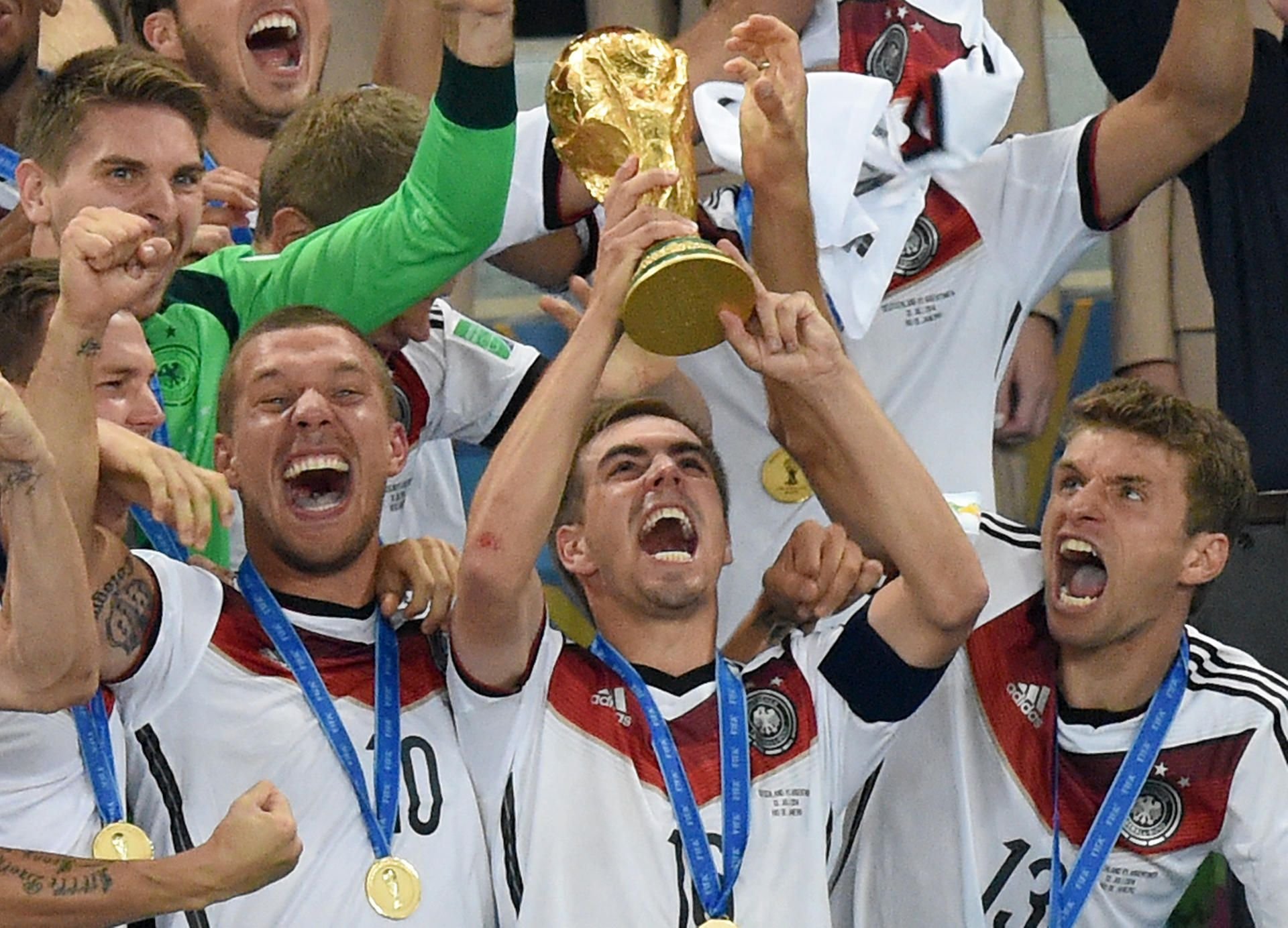 Philipp Lahm streckt den WM-Pokal nach dem Finale 2014 in de Abendhimmel von Rio.