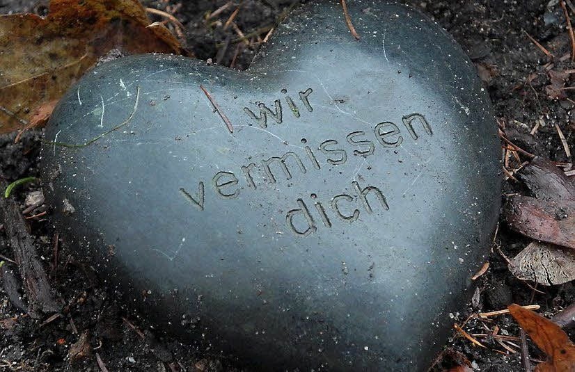 Ein Stein in Herzform auf einem Grab.