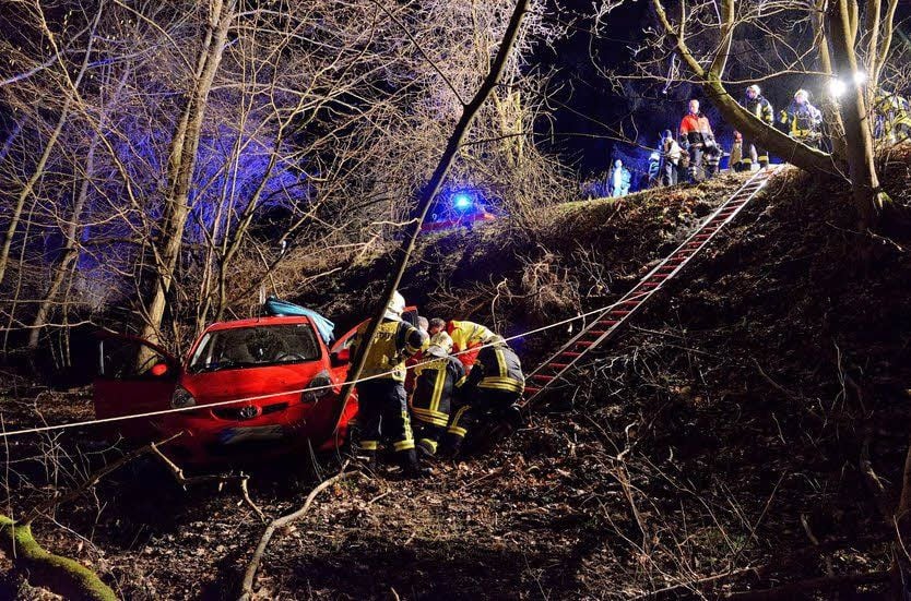 Einsatzkräfte der Feuerwehren Quedlinburg und Gernrode bergen den Mann, dessen Auto einen Abhang hinuntergerollt war.