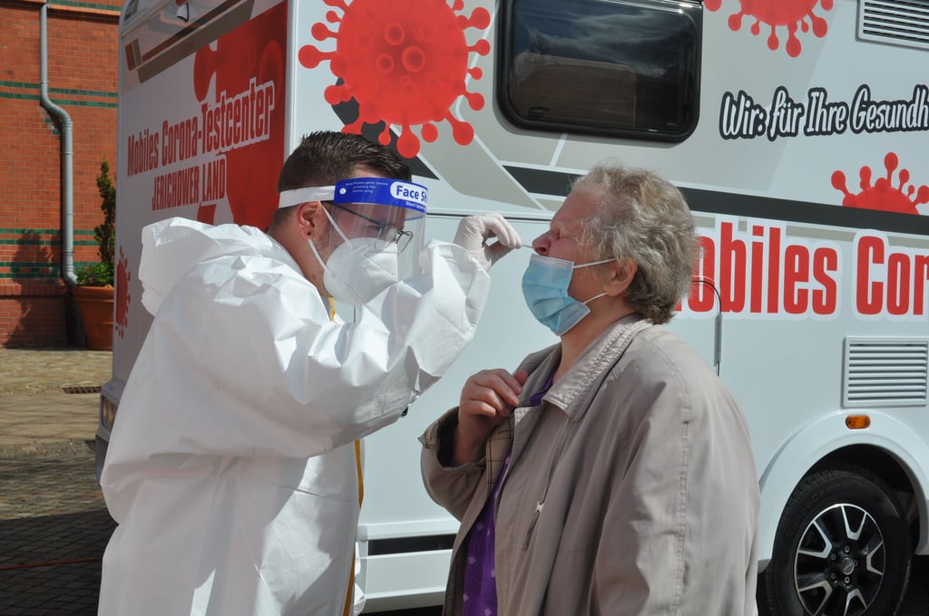 DRK-Notfallsanitäter Burghard Dorst entnimmt Dagmar Plotzki die Proben aus der Nase.