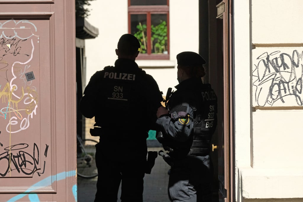 Polizisten stehen in einem Hauseingang im Stadtteil Connewitz.