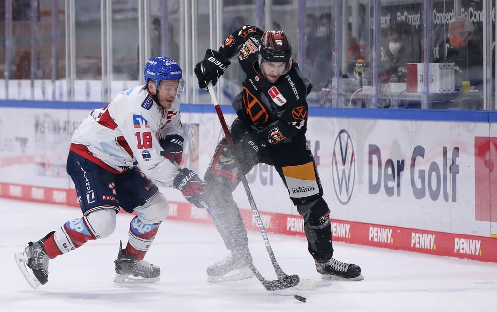 Der Wolfsburger Matti Järvinen (r) kämpft gegen den Mannheimer Ben Smith (l) um den Puck.