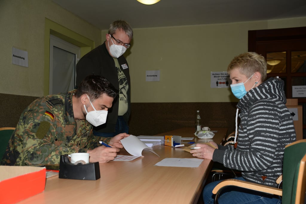 Katrin Kutzner aus Oschersleben ist als Wahlhelferin registriert und meldet sich für ihren Termin bei Bundeswehrsoldat Sebastian Lenser und Impfhelfer Marco Peter aus Niederndodeleben an.