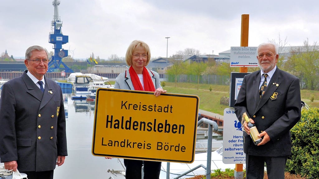 Haldenslebens stellvertretende Bürgermeisterin Sabine Wendler übergab Werner Hanke (links) und Karl-Heinz Stradmann das Ortsschild von Haldensleben für die Fregatte ?Sachsen-Anhalt?.