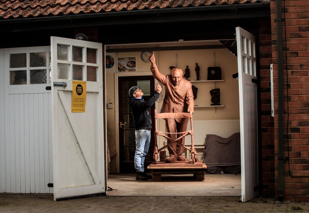 Andrian Melka legt den letzten Schliff an eine zwei Meter hohe Tonstatue von Kapitän Sir Tom Moore in seinem Studio.