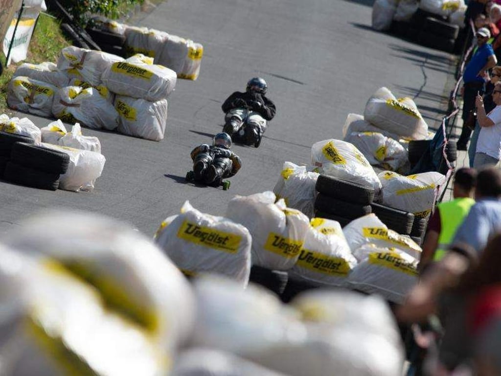 Mit Helm und Ellenbogenschützern geschützt: Auch ohne Motor können die Teilnehmer der hessischen Big-Bobby-Car-Meisterschaft sehr schnell werden. Foto: Swen Pförtner