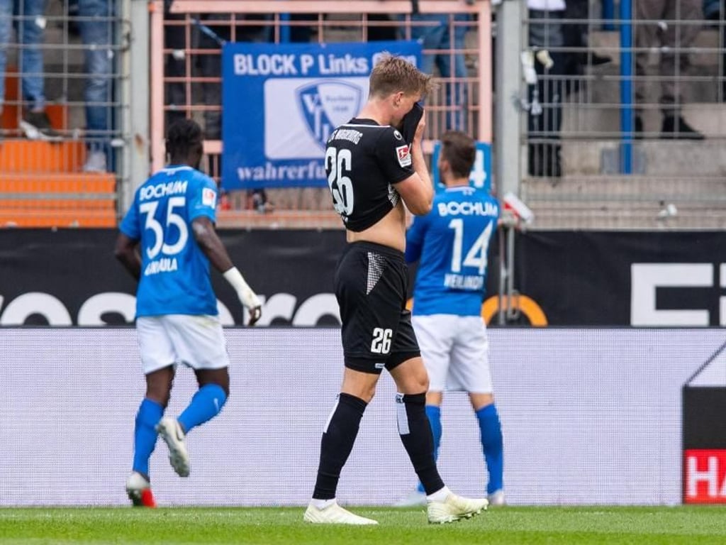 Bochums Spieler feiern das Tor zum 3:0 Magdeburgs Marius Bülter (M) kann es nicht mit ansehen. Foto: Guido Kirchner
