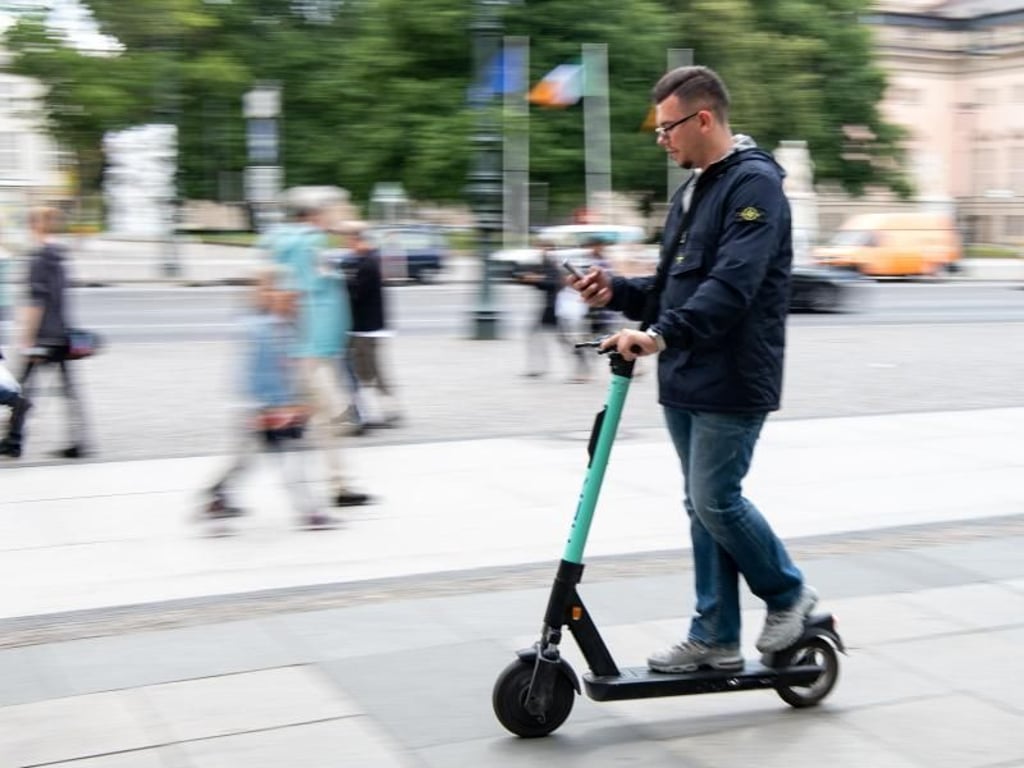 Auf zwei winzigen Rädern im Innenstadtverkehr, die Augen fest aufs Handy geheftet: Ein Tourist fährt durch Berlin-Mitte. Foto: Bernd von Jutrczenka