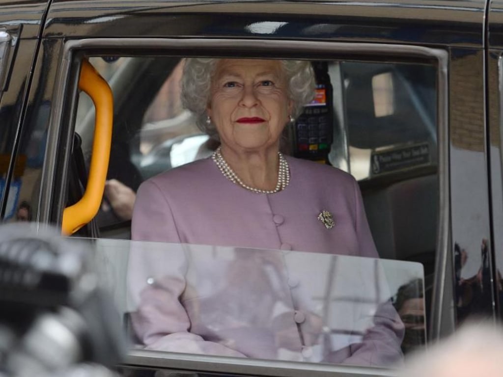 Täuschend echt: Die Queen fährt in einem Taxi am St. Mary's Krankenhaus vorbei. Allerdings ist es nur eine Wachsfigur der Königin. Foto: Kirsty O'connor/PA Wire
