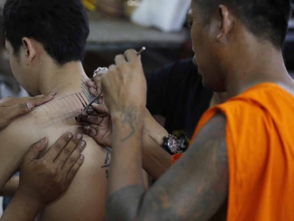 Ein buddhistischer Mönch tätowiert auf traditionelle Weise spirituelle Motive. Foto: Narong Sangnak