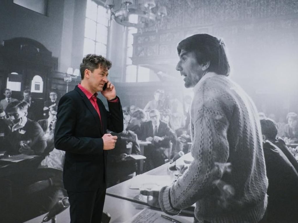 Der Direktor des Kunstmuseums in Wolfsburg, Ralf Beil, telefoniert. Im Hintergrund ein Bild von Rudi Dutschke bei seiner Rede in der Prager Karls Universität. Foto: Ole Spata