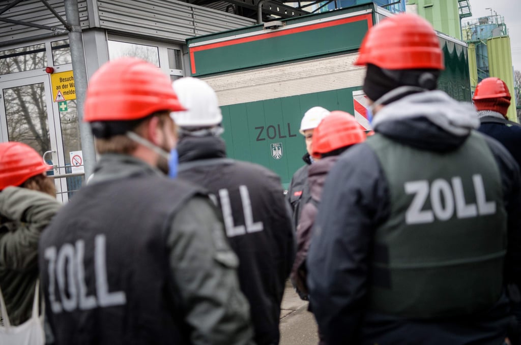 Zollbeamte begleiten am 19.12.2017 einen Lastkraftwagen des Zolls, der mit rund einer halben Tonne Marihuana beladen ist, über das Gelände der Müllverbrennungsanlage in Olching (Bayern). Die 550 Kilogramm Marihuana, die der Zoll in der Müllverbrennungsanlage vernichtet hat, haben Zollbeamte im Dezember 2016 auf einem Autohof an der A9 aus einem Hohlraum eines serbischen LKWs sichergestellt. Foto: Matthias Balk/dpa +++(c) dpa - Bildfunk+++ | Verwendung weltweit
