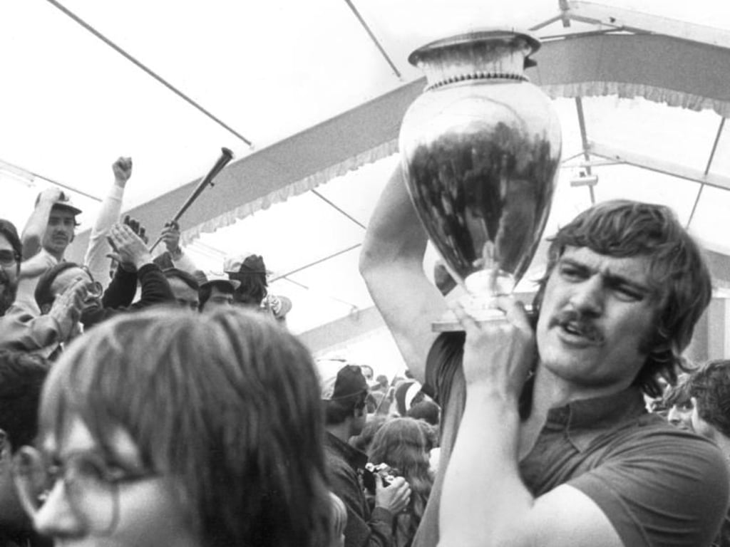 Kurt Klühspies vom TV Großwallstadt geht mit dem Europapokal am 30.04.1979 durch ein Spalier von Fans. Ein Dorf stand Kopf, als der TV Großwallstadt mit dem am Vortag in Rostock gewonnenen Pokal in das Festzelt der 3.147-Seelengemeinde einzog. Foto: Heinz Wieseler