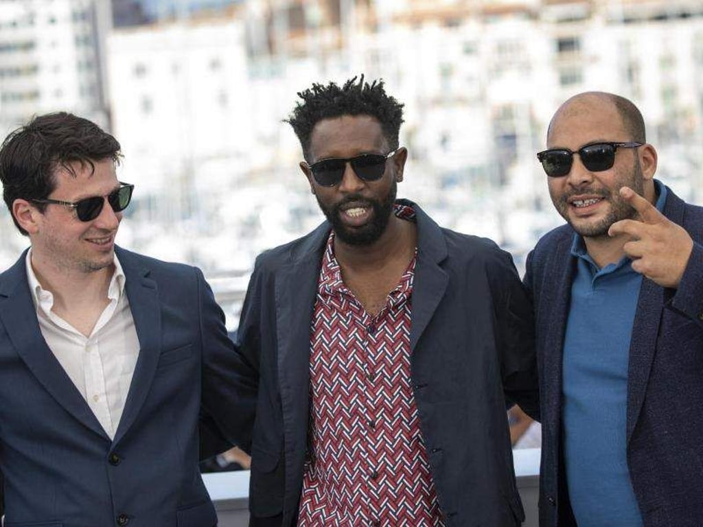 Regisseur Ladj Ly (M) mit den Produzenten Christophe Barral (l) und Toufik Ayadi beim Filmfest in Cannes. Foto: Vianney Le Caer/Invision/AP