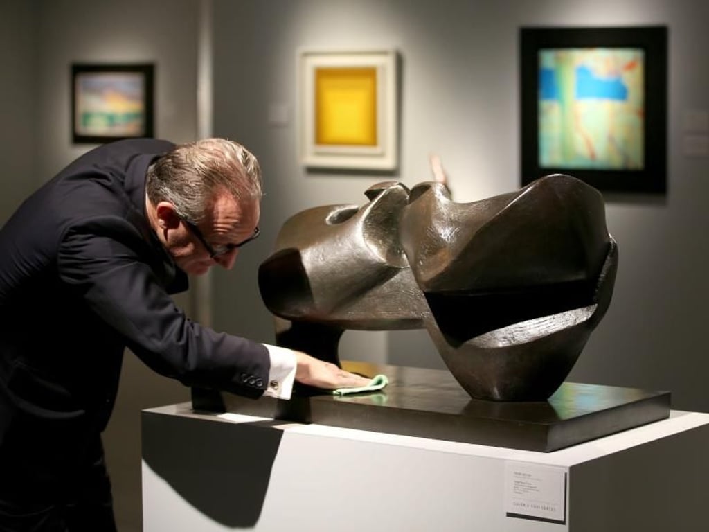 Der Galerist putzt noch einmal über die Skulptur «Large slow form» von Henry Moore. Foto: Oliver BErg