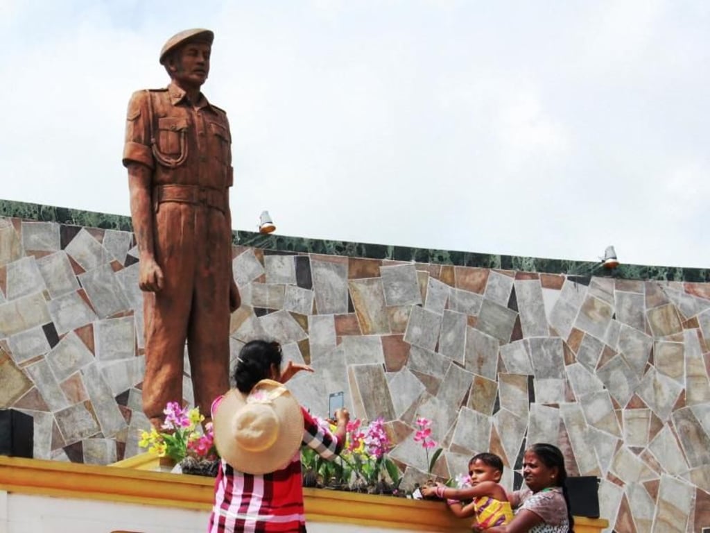 Eine Familie gedenkt vor einem Monument in Kilinochchi einem singhalesischen Kriegshelden. Foto: Dagmar Gehm