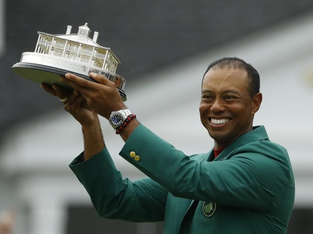 Stolz präsentiert Woods im grünen Sieger-Jackett die Trophäe für seinen fünften Sieg. Foto: Matt Slocum/AP