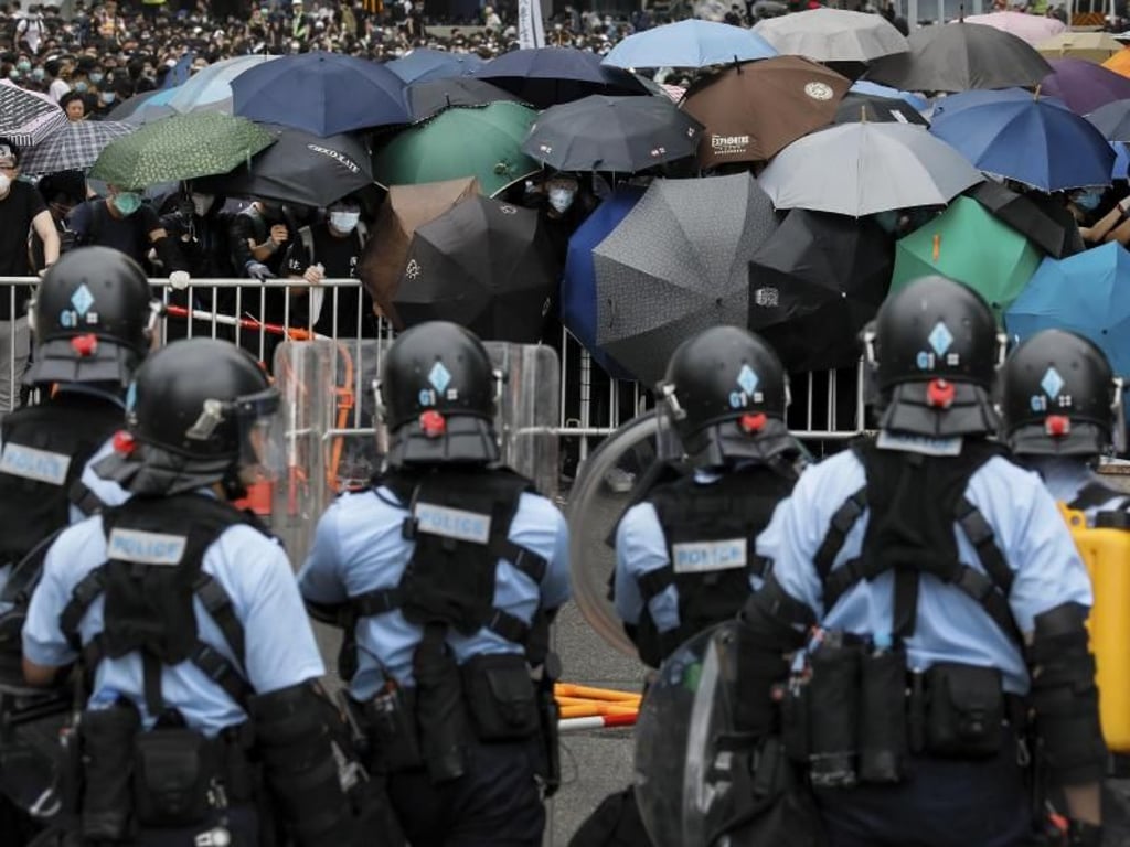 Polizisten stehen in der Nähe des Legislativrates Demonstranten gegenüber. Foto: Vincent Yu/AP