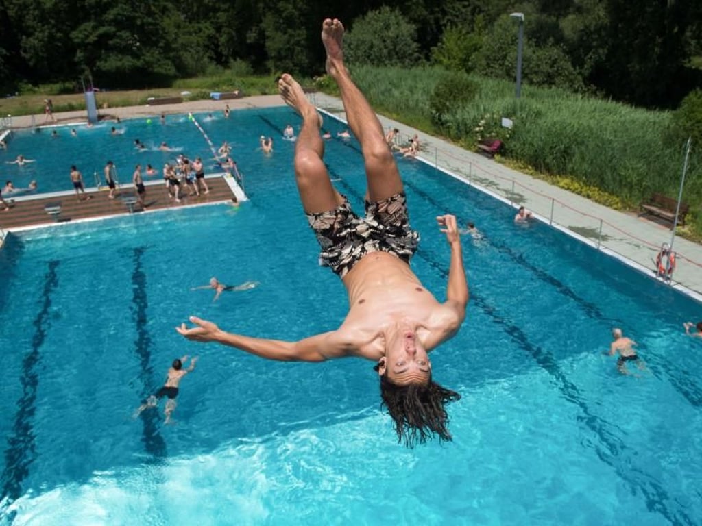 Leopold springt im Freibad Wostra in Dresden vom 5-Meter-Turm ins Wasser. Foto: Sebastian Kahnert