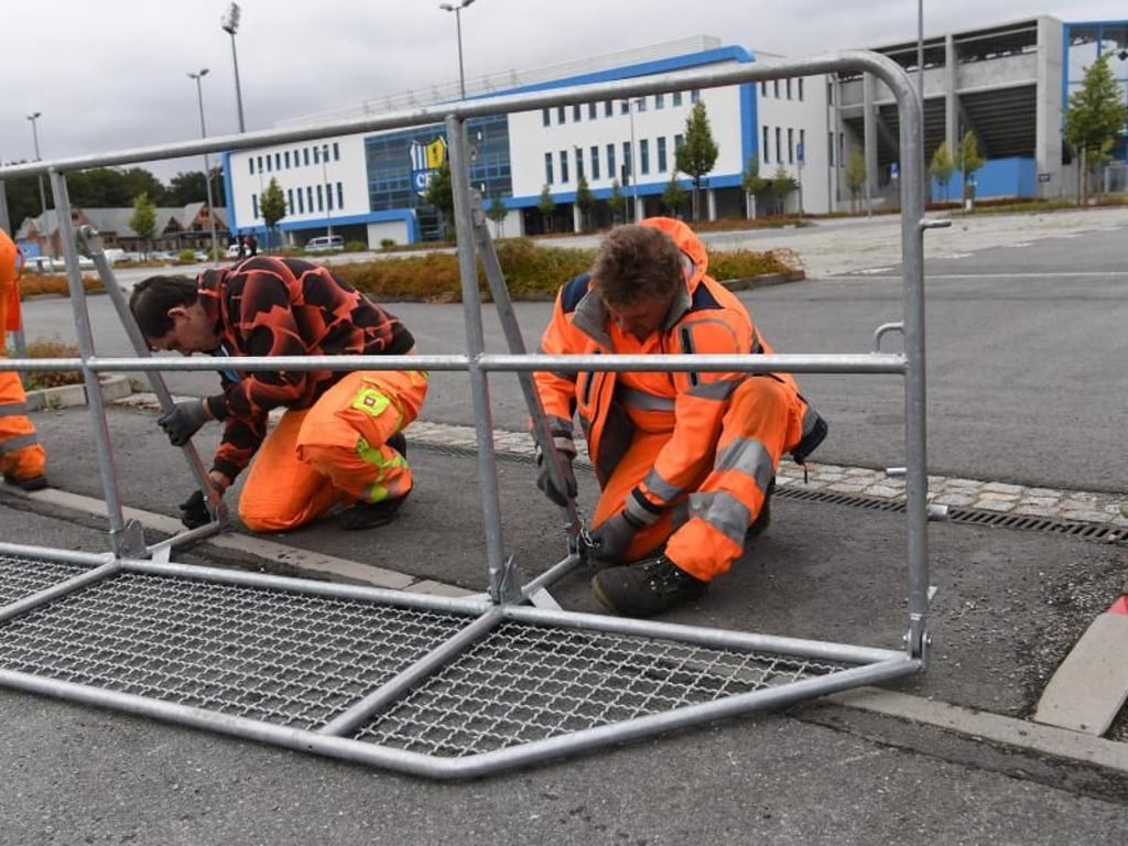 Vorbereitungen in Chemnitz: Arbeiter errichten Absperrgitter von dem Stadion, wo die rechtspopulistische Bewegung Pro Chemnitz demonstrieren wil. Foto: Ralf Hirschberger