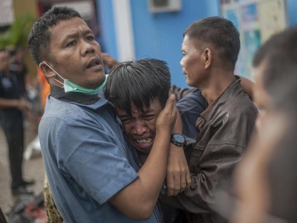 Ein Mann reagiert, nachdem er einen Verwandten als Opfer der Todeswelle identifiziert hat. Foto: Fauzy Chaniago/AP