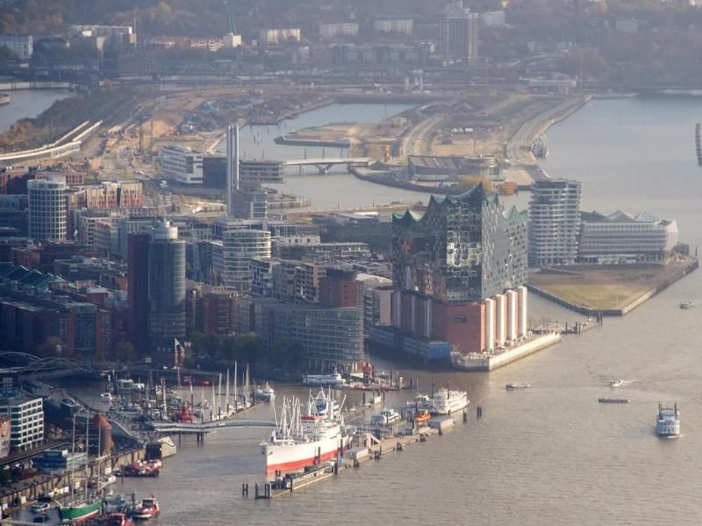 Blick auf den Hafen mit den Landungsbrücken (l), der Elbphilharmonie (M) und dem Stadtteil HafenCity (oben). Foto: Daniel Bockwoldt