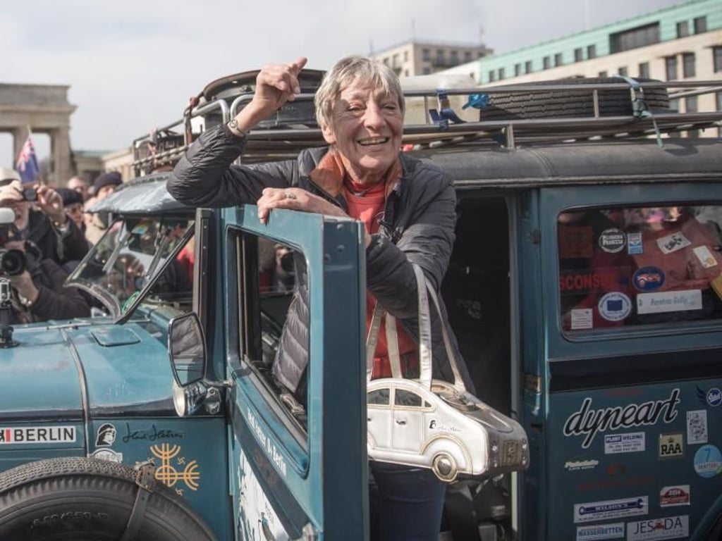Heidi Hetzer nach ihrer Weltreise in einem Oldtimer am Brandenburger Tor in Berlin. Foto: Jörg Carstensen